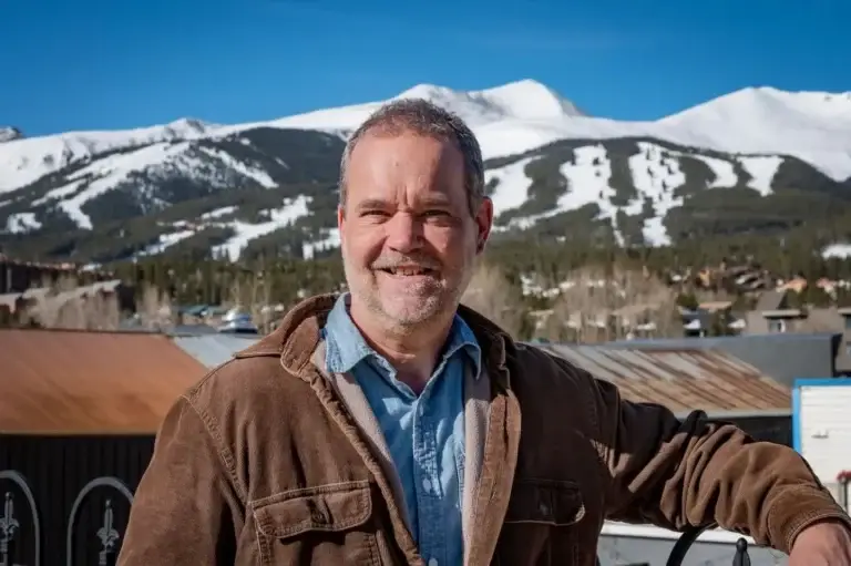 Dan Skala owner of Exclusive Cleaning and Restoration poses for a headshot in front of Breckenridge Ski Resort.