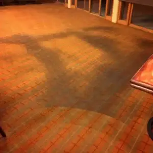 An orange/ red colored carpet with a very large dark stain. Photo taken before a professional carpet cleaning at Copper Mountain, Colorado