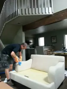 A person performing a professional upholstery cleaning in a home in Summit County Colorado.